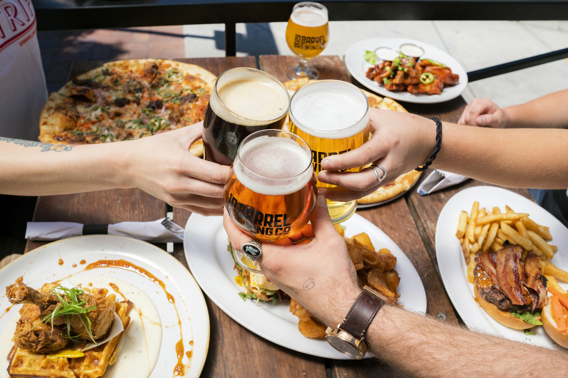 Groupe d’amis qui trinquent autour d’une table partagée